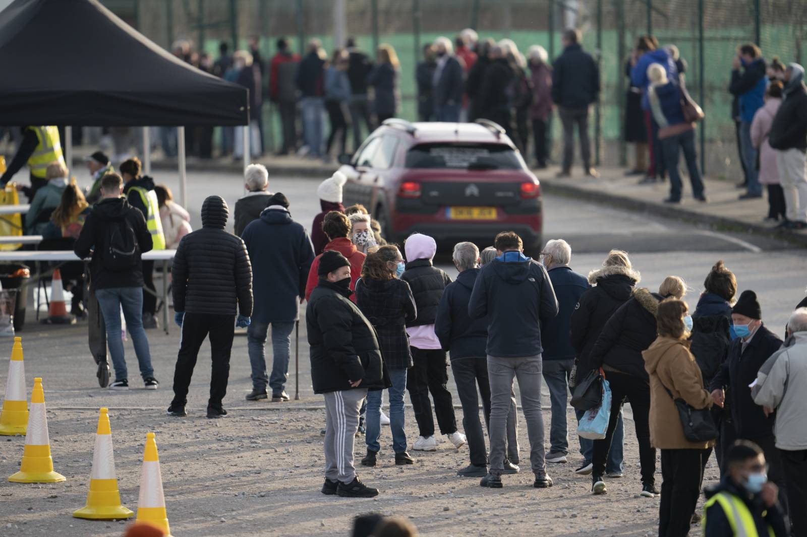 11月6日，人們在英國利物浦的一處新冠病毒檢測點排隊等待檢測。（新華社）