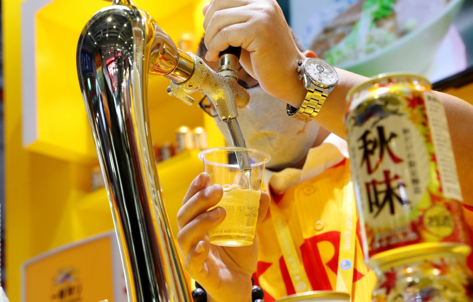 工作人員在進博會食品及農產品展區麒麟啤酒展台上倒啤酒。