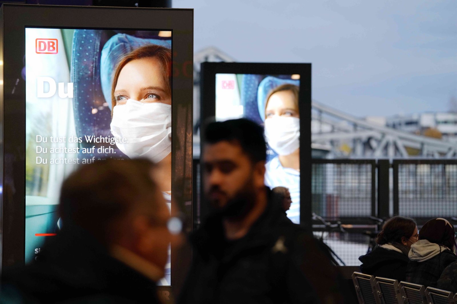 圖為16日下午，柏林健康泉車站內提醒人們乘車佩戴口罩的廣告。