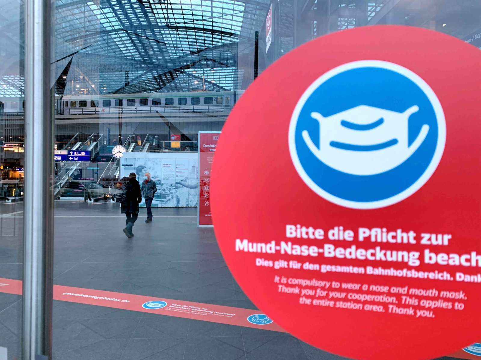 圖為16日下午，柏林火車總站門口貼有提醒人們進入車站必須佩戴口罩的標識。