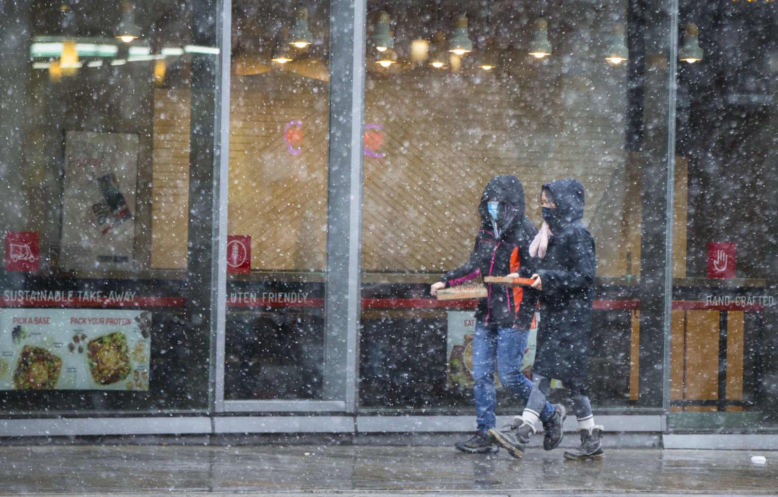 11月22日，在加拿大安大略省多倫多，行人在街頭冒雪前行。