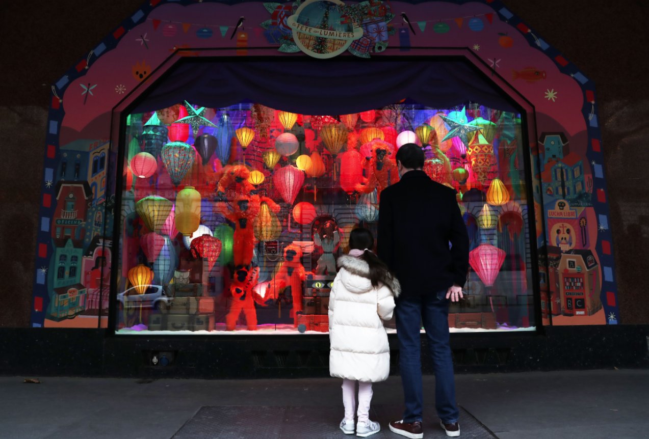 11月22日，一對父女在法國巴黎老佛爺百貨商店的聖誕櫥窗前駐足欣賞。（新華社）
