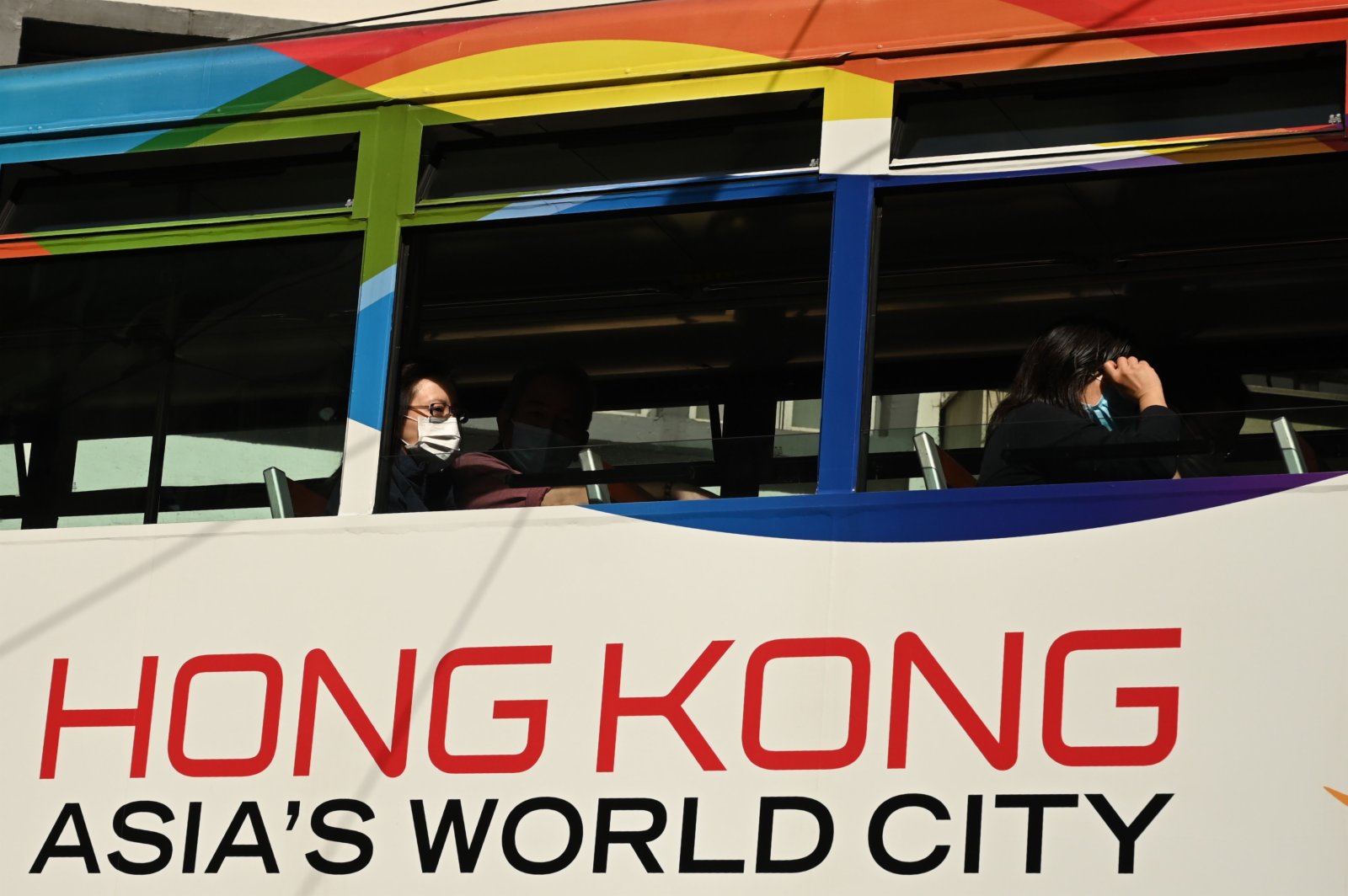 在香港街頭，市民戴着口罩乘坐有軌電車。（法新社圖片）