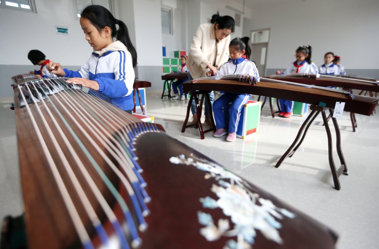 12月1日，山東省青島市即墨區龍山中心小學古箏社團的學生在老師的指導下彈奏古箏。（新華社）