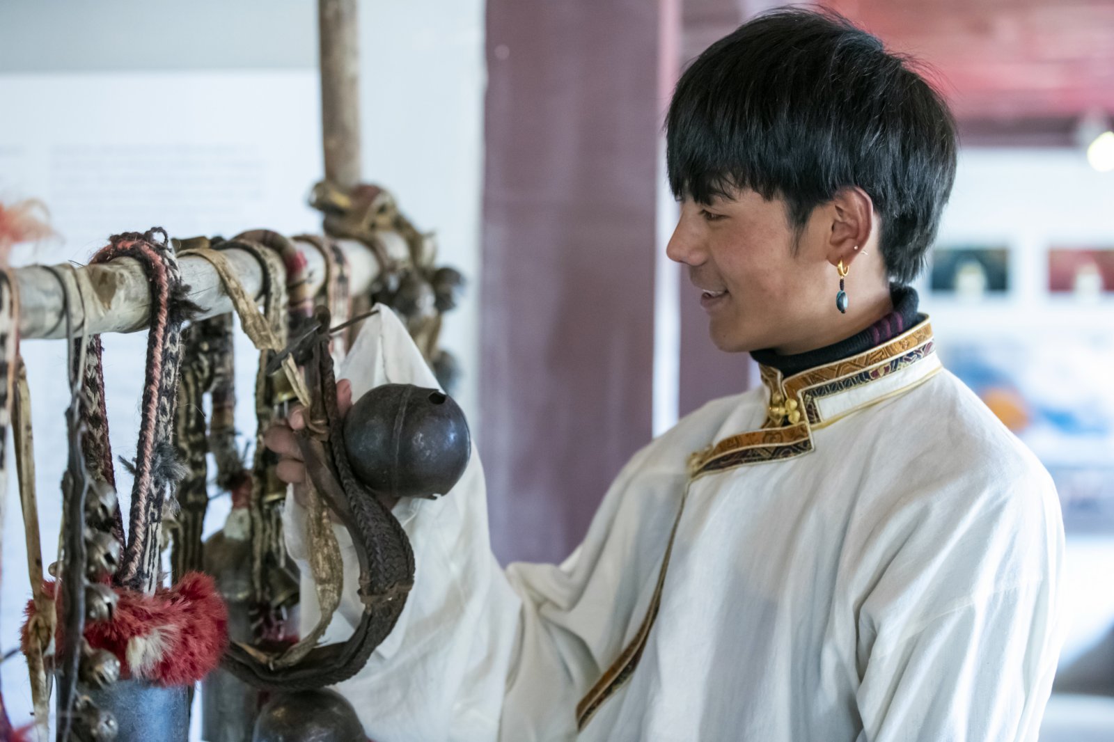 在理塘縣勒通古鎮的喜馬拉雅之聲微博物館，丁真撥動當地傳統的一些用具、器物，如銅鈴、馬鞍等，聆聽它們發出的聲響。