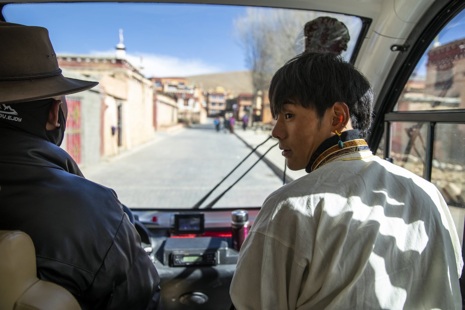 在理塘縣勒通古鎮，丁真（右）乘坐旅遊擺渡車前往一個微型博物館以熟悉自己未來的工作場所。