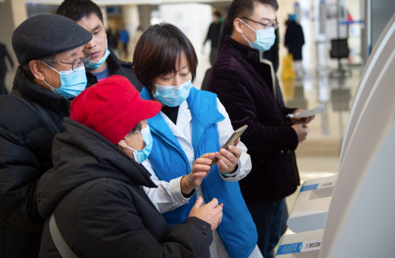 12月9日,首都醫科大學附屬北京天壇醫院的工作人員幫助老年人使用手機繳費。(新華社) 12月9日,首都醫科大學附屬北京天壇醫院的工作人員幫助老年人使用手機繳費。(新華社)