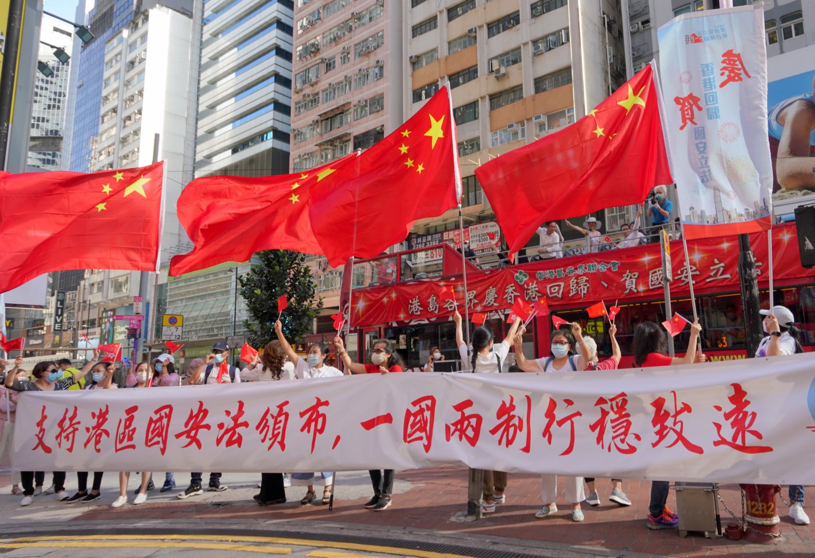6月30日下午，香港市民來到銅鑼灣街頭慶祝《香港國安法》頒布。大家揮舞五星紅旗和香港區旗，高唱國歌和愛國歌曲，贏得街頭市民的陣陣掌聲。（中新社）