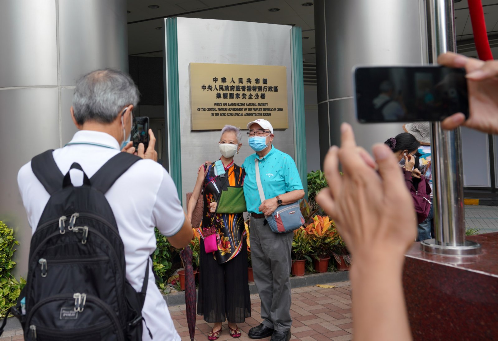 7月8日下午，香港市民在中央人民政府駐香港特別行政區維護國家安全公署牌匾前拍照留念。當天上午，中央政府駐港維護國家安全公署正式揭牌成立。 （中新社）