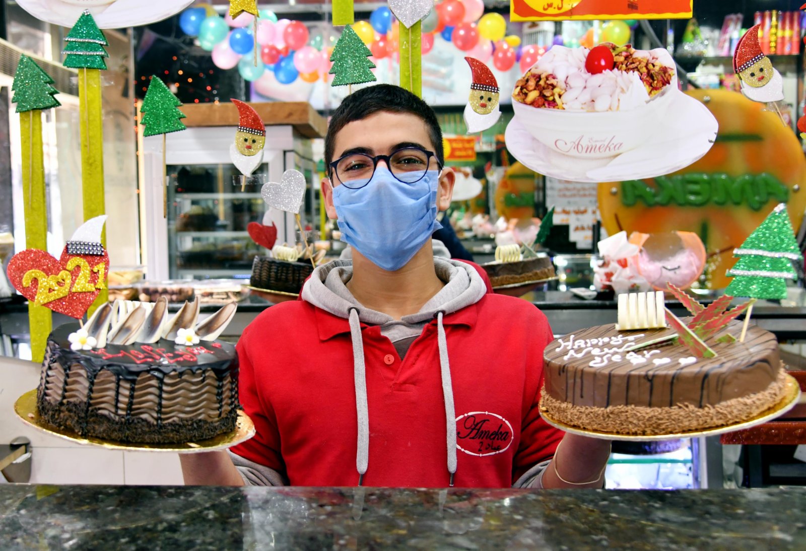 2020年12月31日，在敘利亞大馬士革一家甜品店，店員展示新年蛋糕。（新華社）