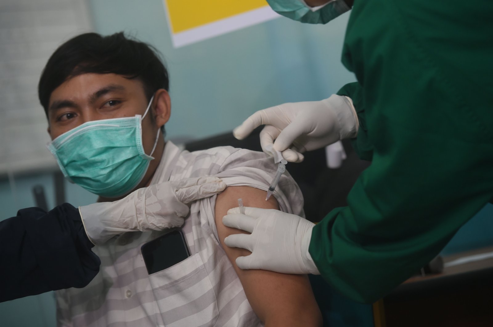 1月15日，在印度尼西亞萬丹省南唐格朗，醫務人員展示中國科興公司的克爾來福新冠疫苗。（新華社）
