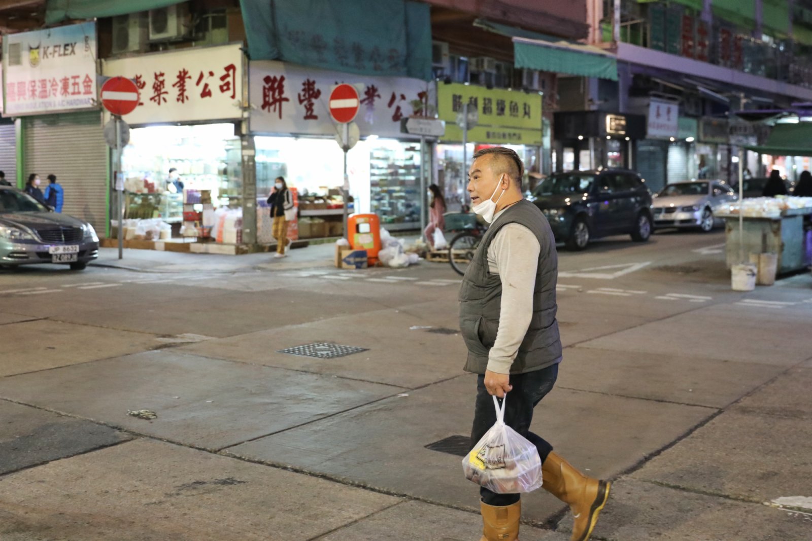 1月15日，香港油麻地再有樓宇有確診個案，碧街15至27A多兩單位有住客確診，需列入強制檢測名單。圖為大廈附近依然有市民未正確配戴口罩出行。（香港中通社）