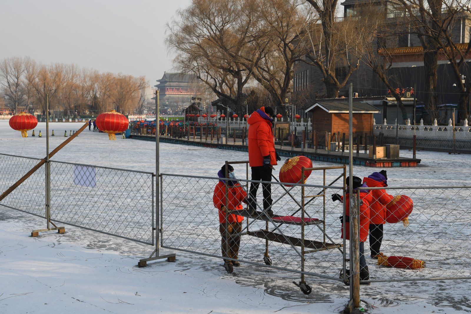 工作人員拆下冰場圍欄上的燈籠。（中新社）