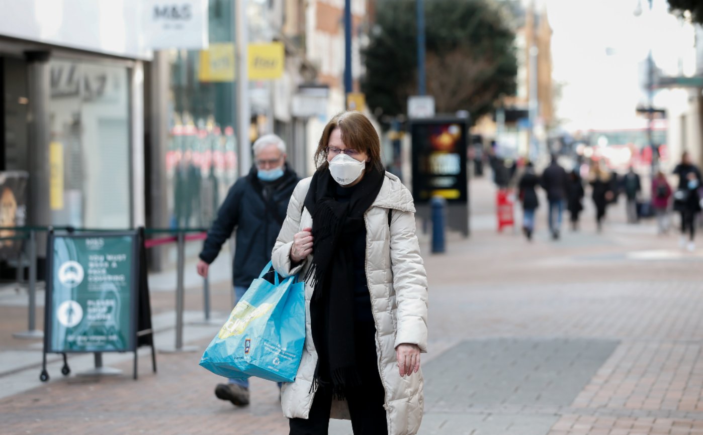 1月21日，戴口罩的人們在英國泰晤士河畔金斯頓街頭行走。（新華社）