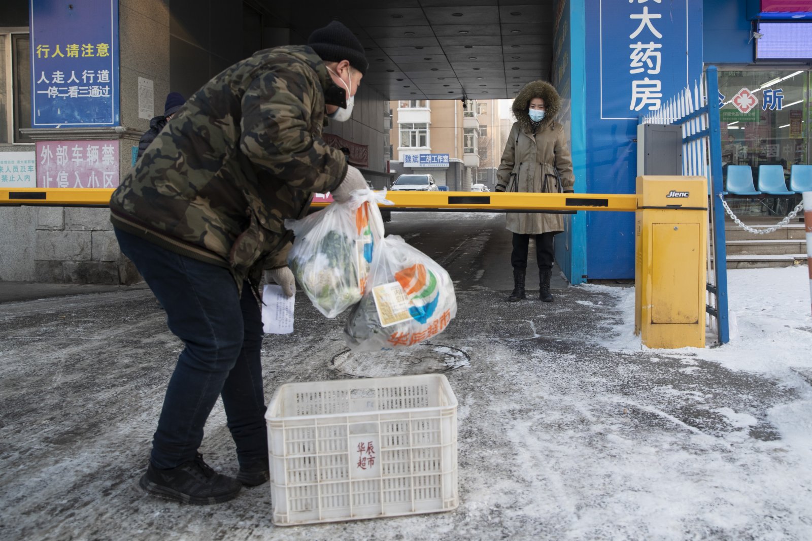 1月22日，超市配送人員將商品送到綏化市北林區一小區卡點。（新華社）