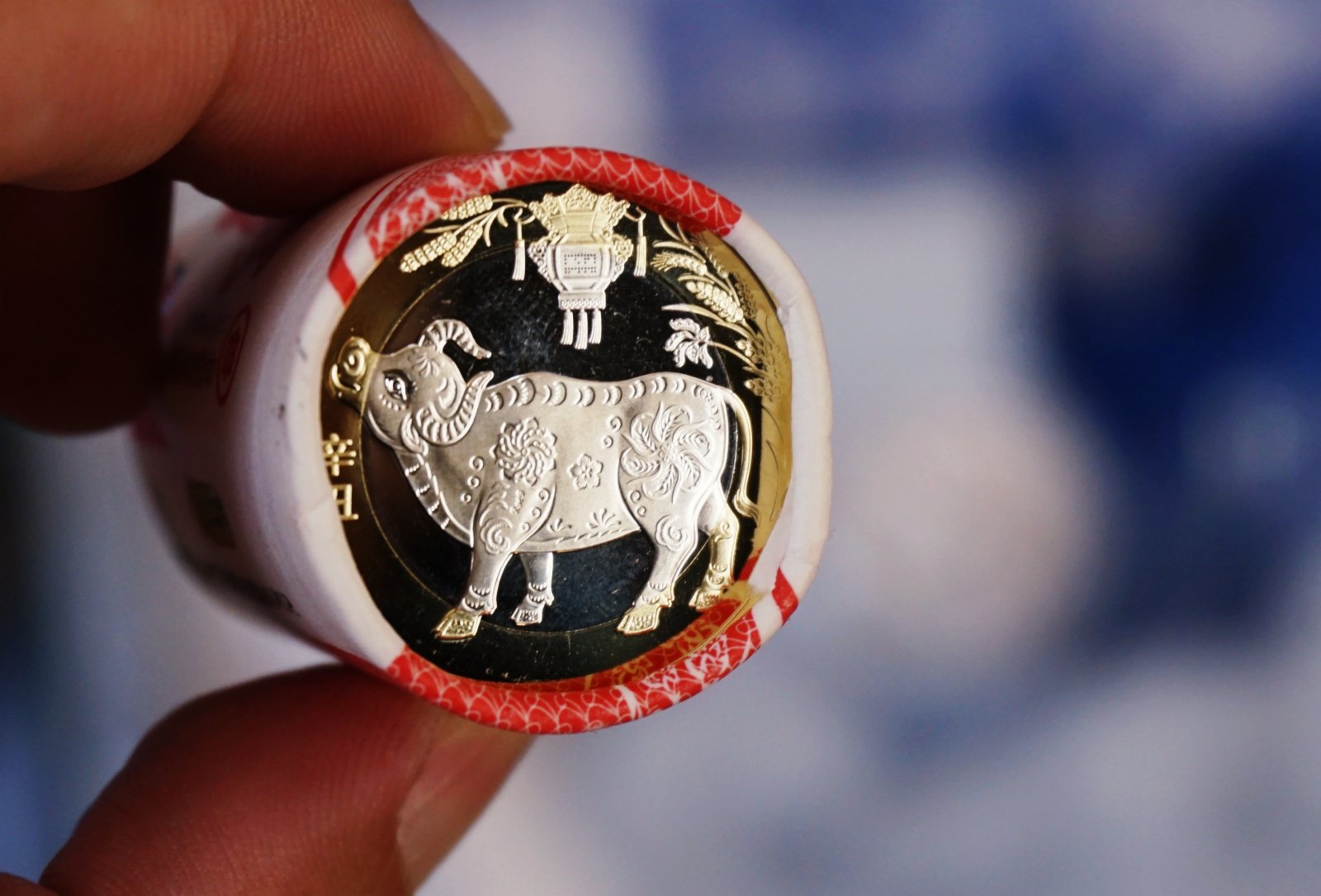 1月29日，杭州市民展示兌換到的紀念幣。當日，中國人民銀行發行的2021年賀歲普通紀念幣開始兌換。紀念幣背面主景圖案為一頭「抬頭牛」，面額10元，預約兌換數量約1.4億枚。（新華社）