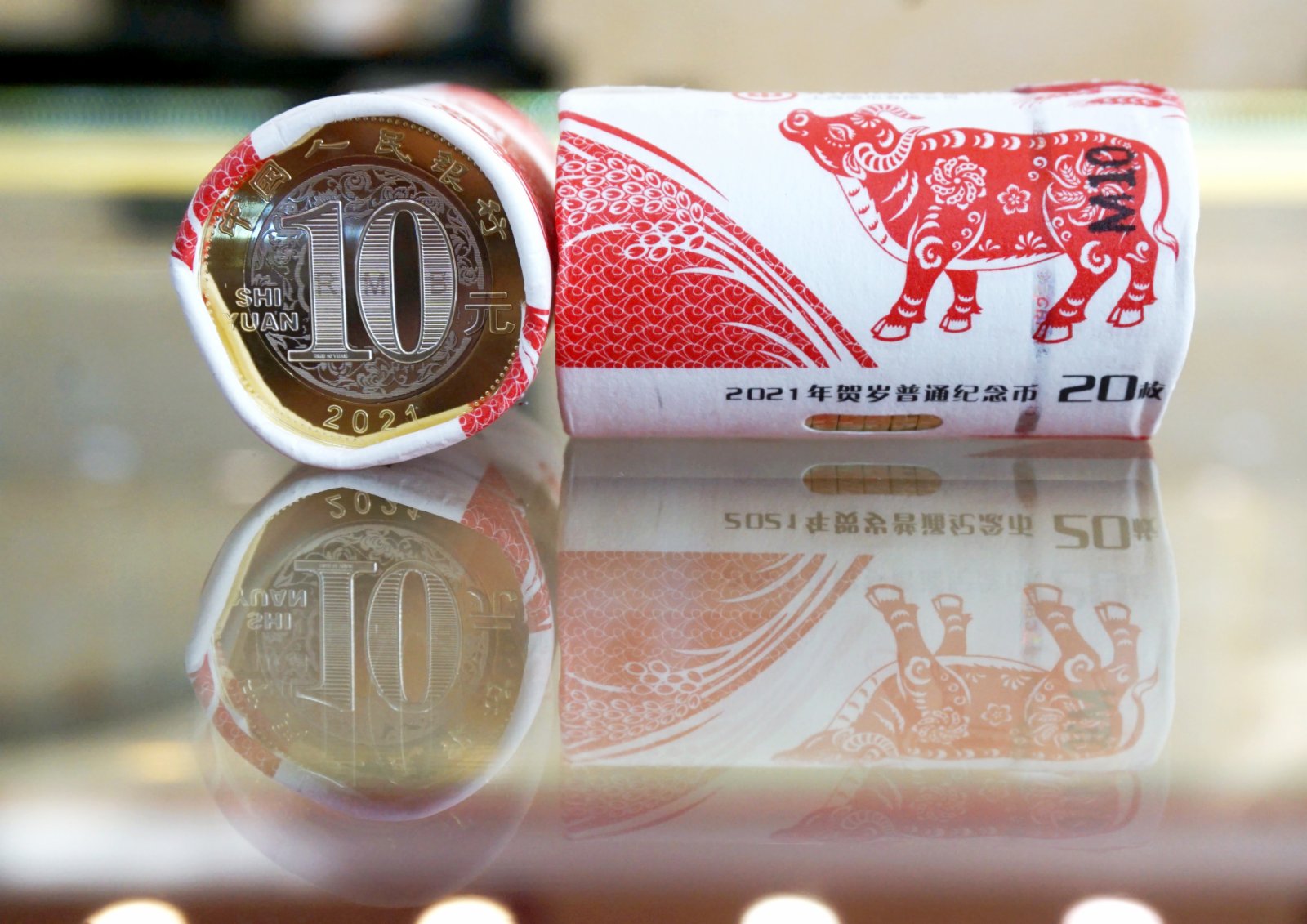 1月29日，杭州市民展示兌換到的紀念幣。當日，中國人民銀行發行的2021年賀歲普通紀念幣開始兌換。紀念幣背面主景圖案為一頭「抬頭牛」，面額10元，預約兌換數量約1.4億枚。（新華社）
