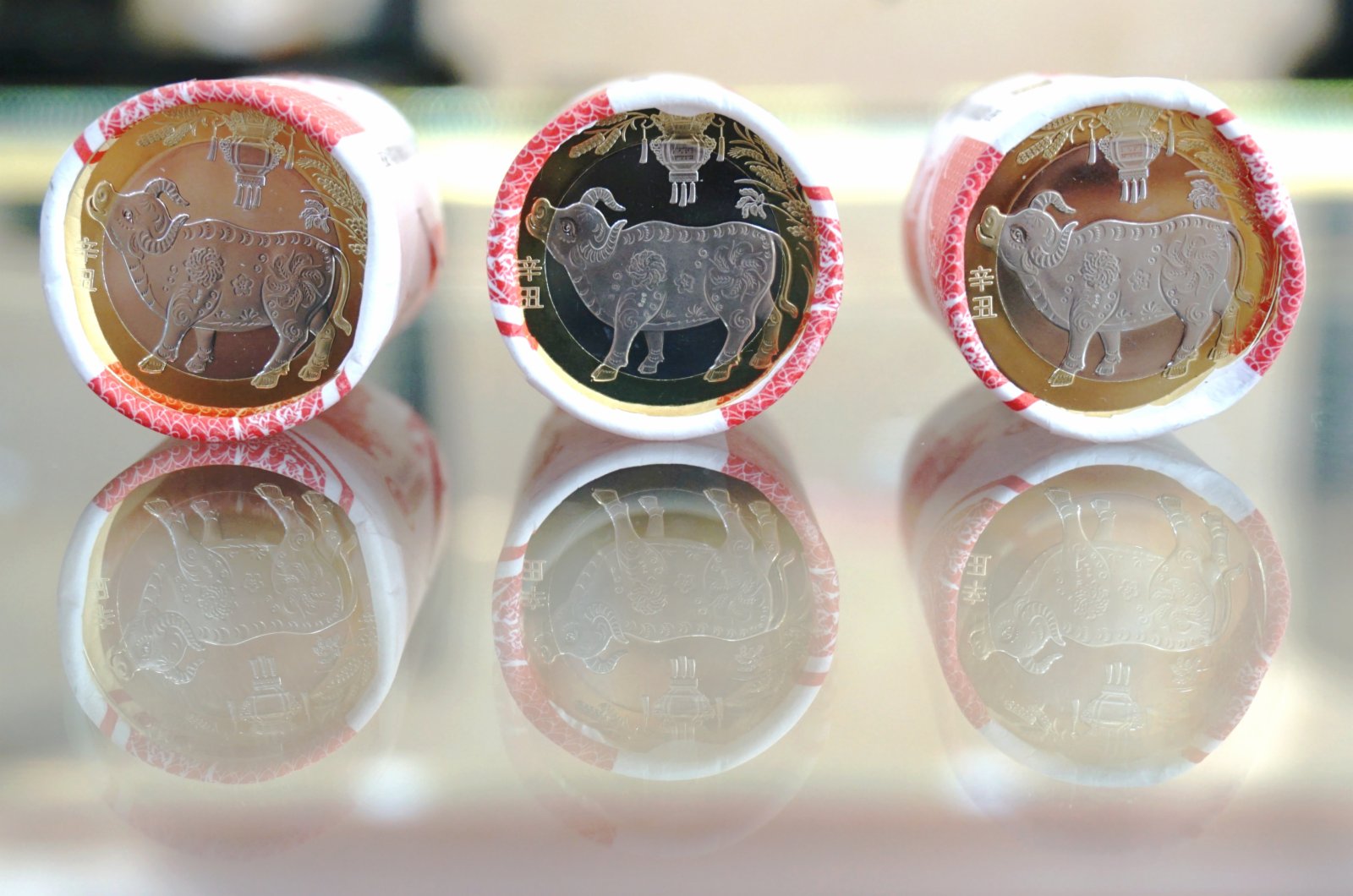 1月29日，杭州市民展示兌換到的紀念幣。當日，中國人民銀行發行的2021年賀歲普通紀念幣開始兌換。紀念幣背面主景圖案為一頭「抬頭牛」，面額10元，預約兌換數量約1.4億枚。（新華社）