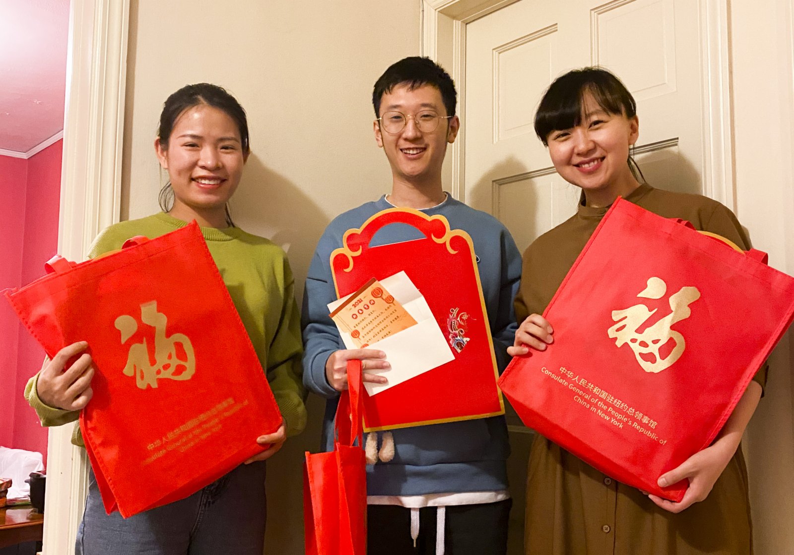 1月22日，霍夫斯特拉大學中國留學生張瑩瑩、牛亨通和李真真（從左到右）在美國紐約展示「春節包」。（新華社）