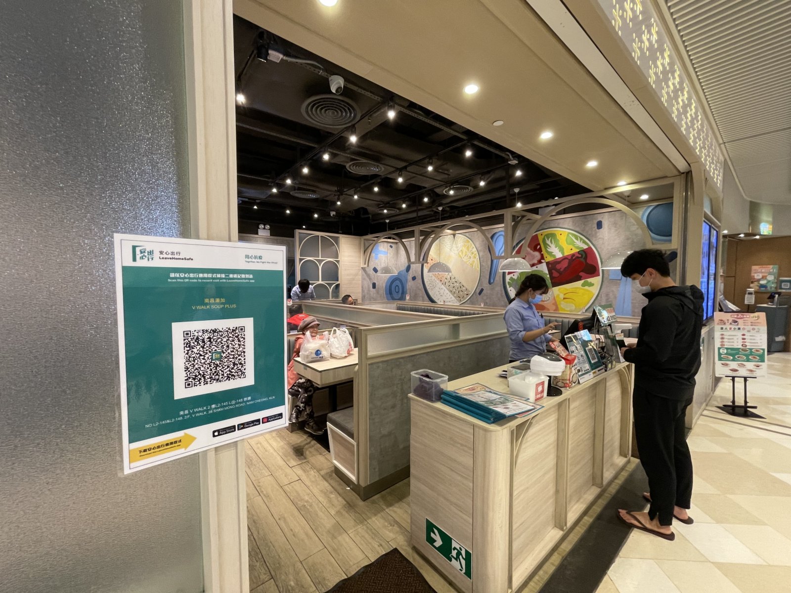 晚市堂食重啟，市民須掃安心出行二維碼或登記資料進入食肆，在商場部分食肆都有張貼安心出行二維碼，旁有工作人員幫助市民進行登記。（大公文匯全媒體記者李湃豐 攝）