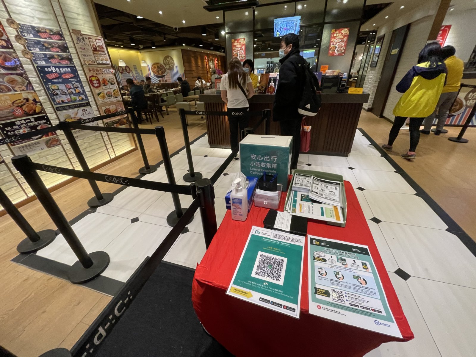 晚市堂食重啟，市民須掃安心出行二維碼或登記資料進入食肆，在商場部分食肆都有張貼安心出行二維碼，旁有工作人員幫助市民進行登記。（大公文匯全媒體記者李湃豐 攝）