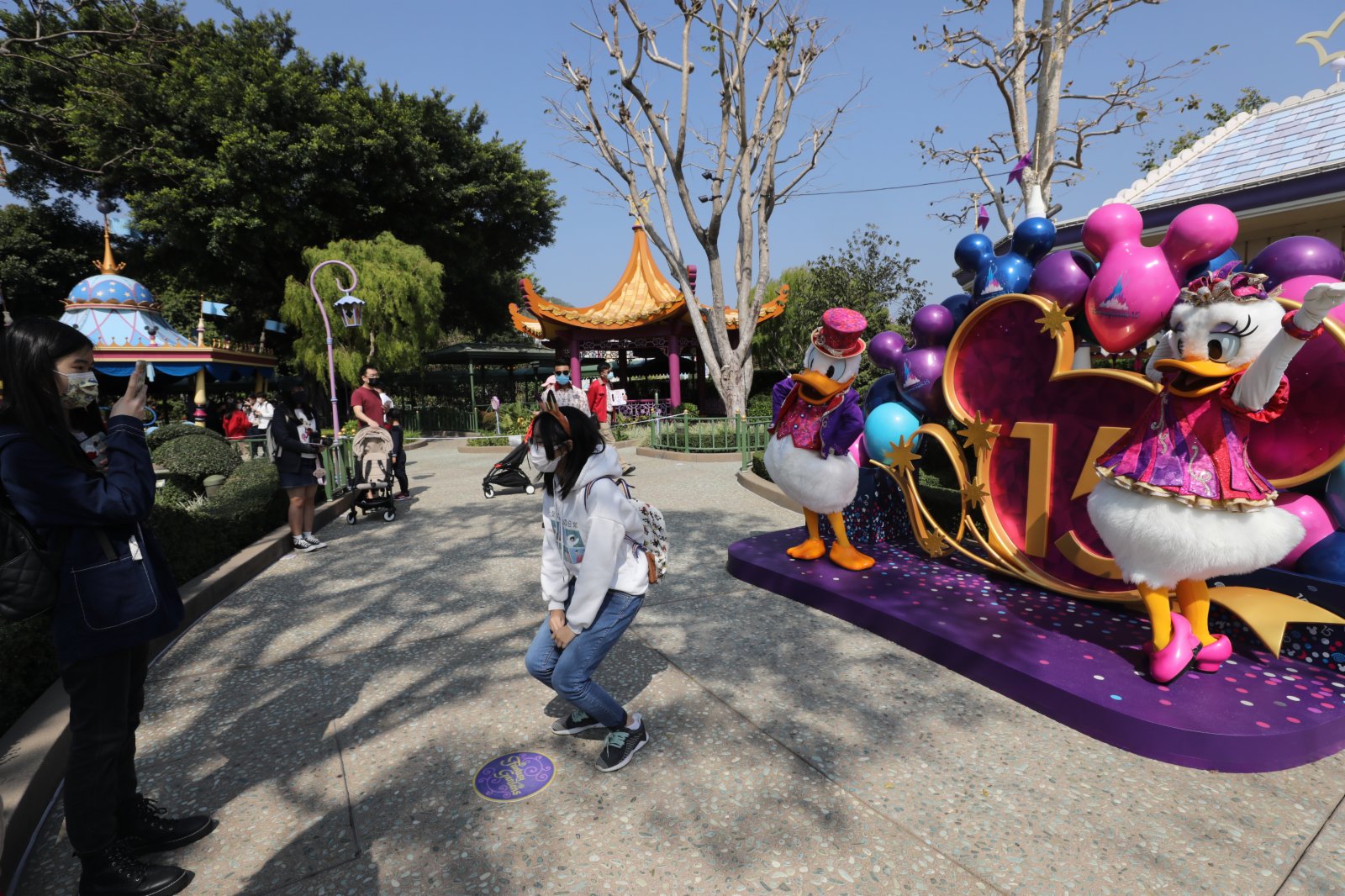 香港迪士尼樂園今日（19日）重開，市民需提前預約入園。園方加強防疫措施，在入口多處展示「安心出行」二維碼，不少市民都自覺掃描。有市民表示，擔心樂園隨時再因疫情嚴重而關閉，已經預約下周再次入園。亦有市民指，以往樂園太多遊客，現時園內空間較為寬鬆，加上足足一年沒有外出旅行，因此前來放鬆。還有中六學生指，迪士尼陪伴他成長，對重開感到興奮。（香港文匯報記者萬霜靈攝）