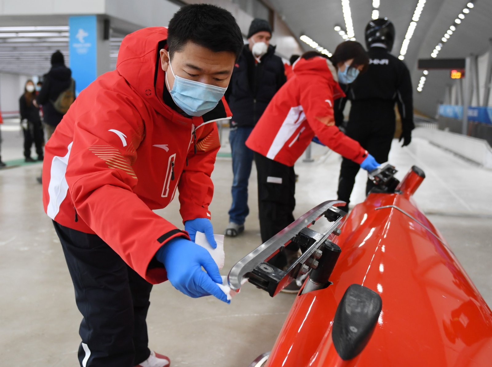在延慶賽區國家雪車雪橇中心，工作人員在比賽前清理滑刃。