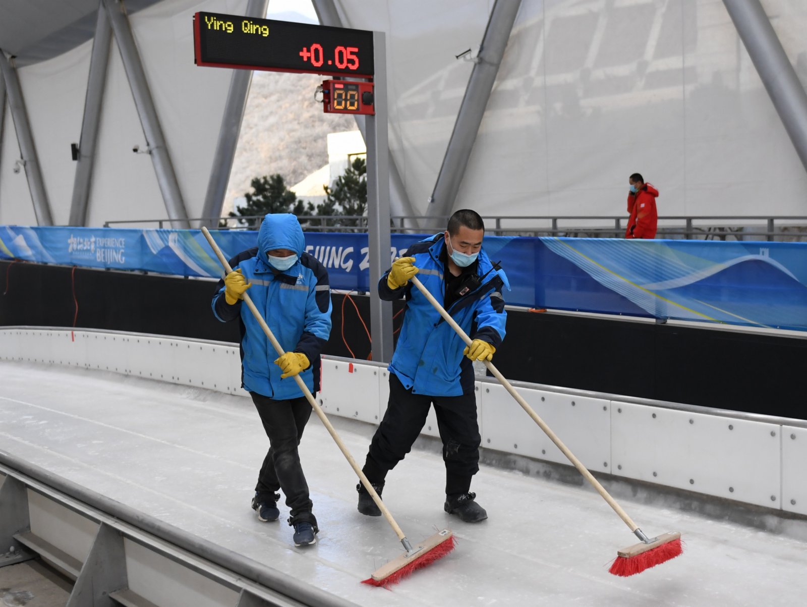 在延慶賽區國家雪車雪橇中心，製冰師在測試活動中清理冰面。