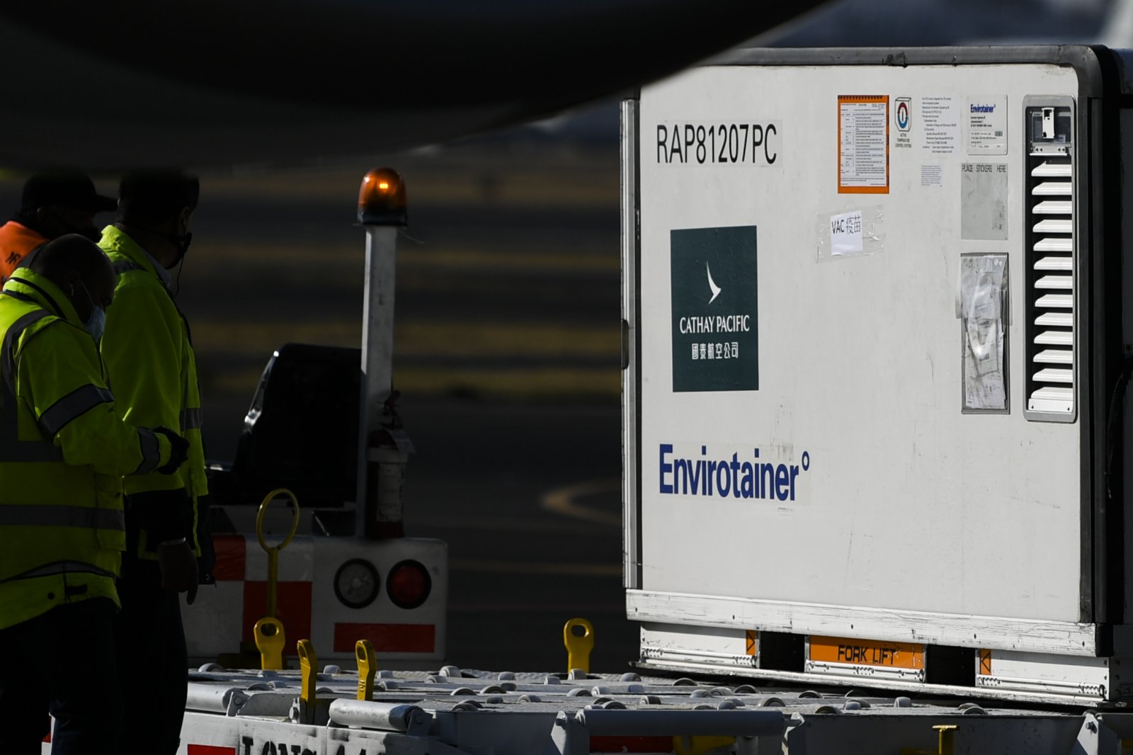 在墨西哥首都墨西哥城國際機場，工作人員從飛機上卸下裝有中國科興新冠疫苗的溫控集裝箱。