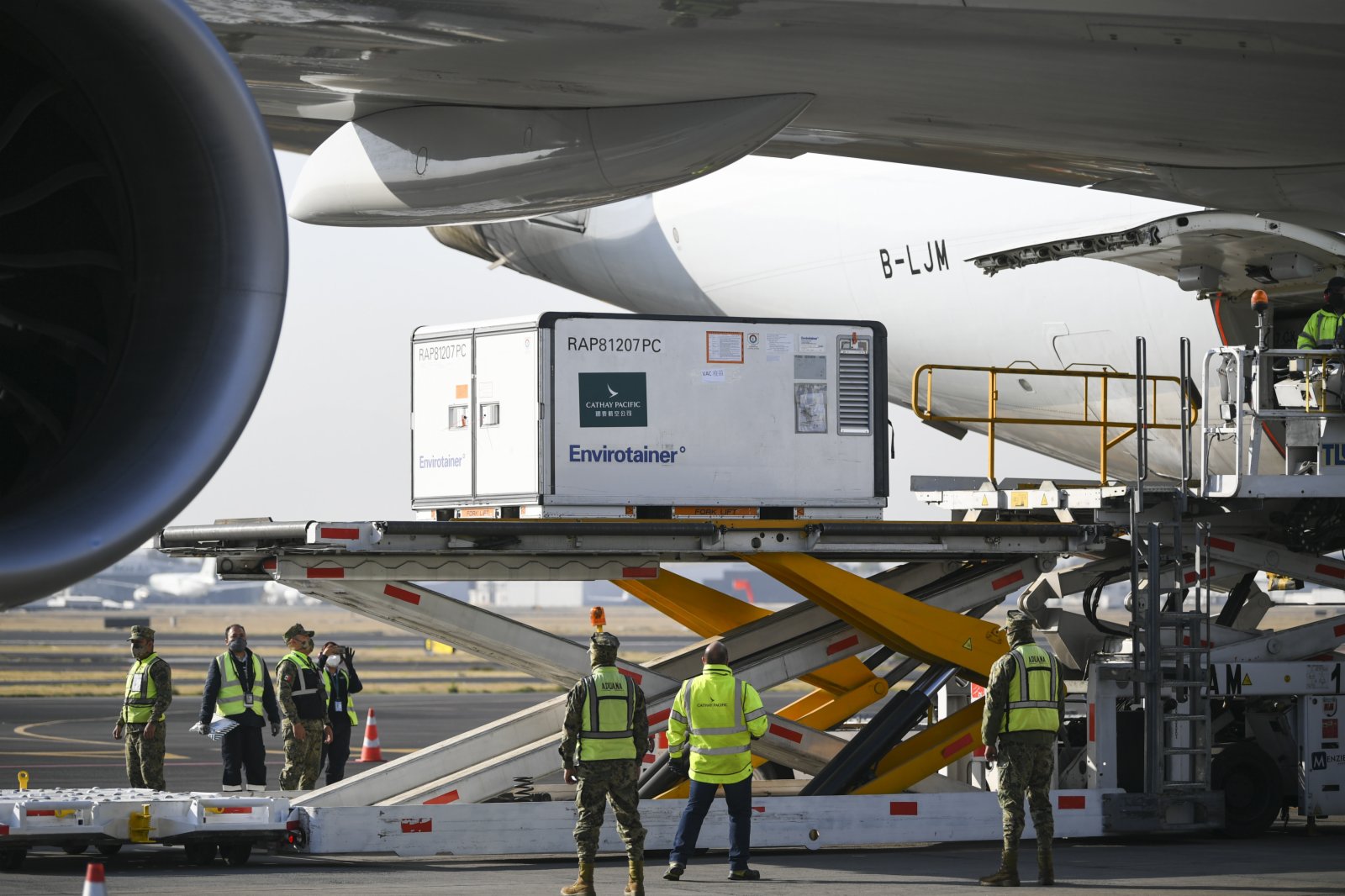 在墨西哥首都墨西哥城國際機場，工作人員從飛機上卸下裝有中國科興新冠疫苗的溫控集裝箱。