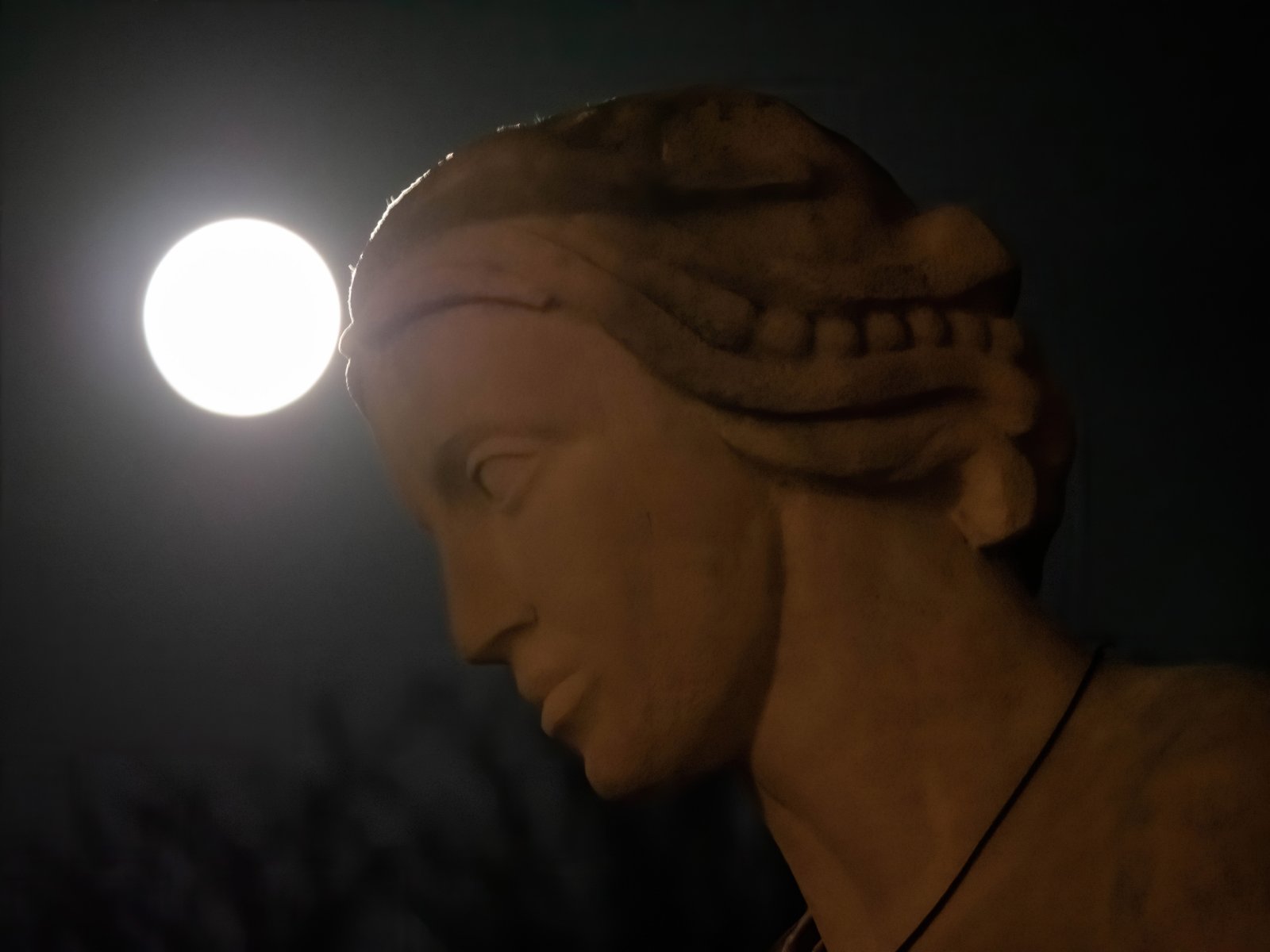 2月26日，在比利時布魯塞爾，一輪圓月與雕塑相映成趣。新華社