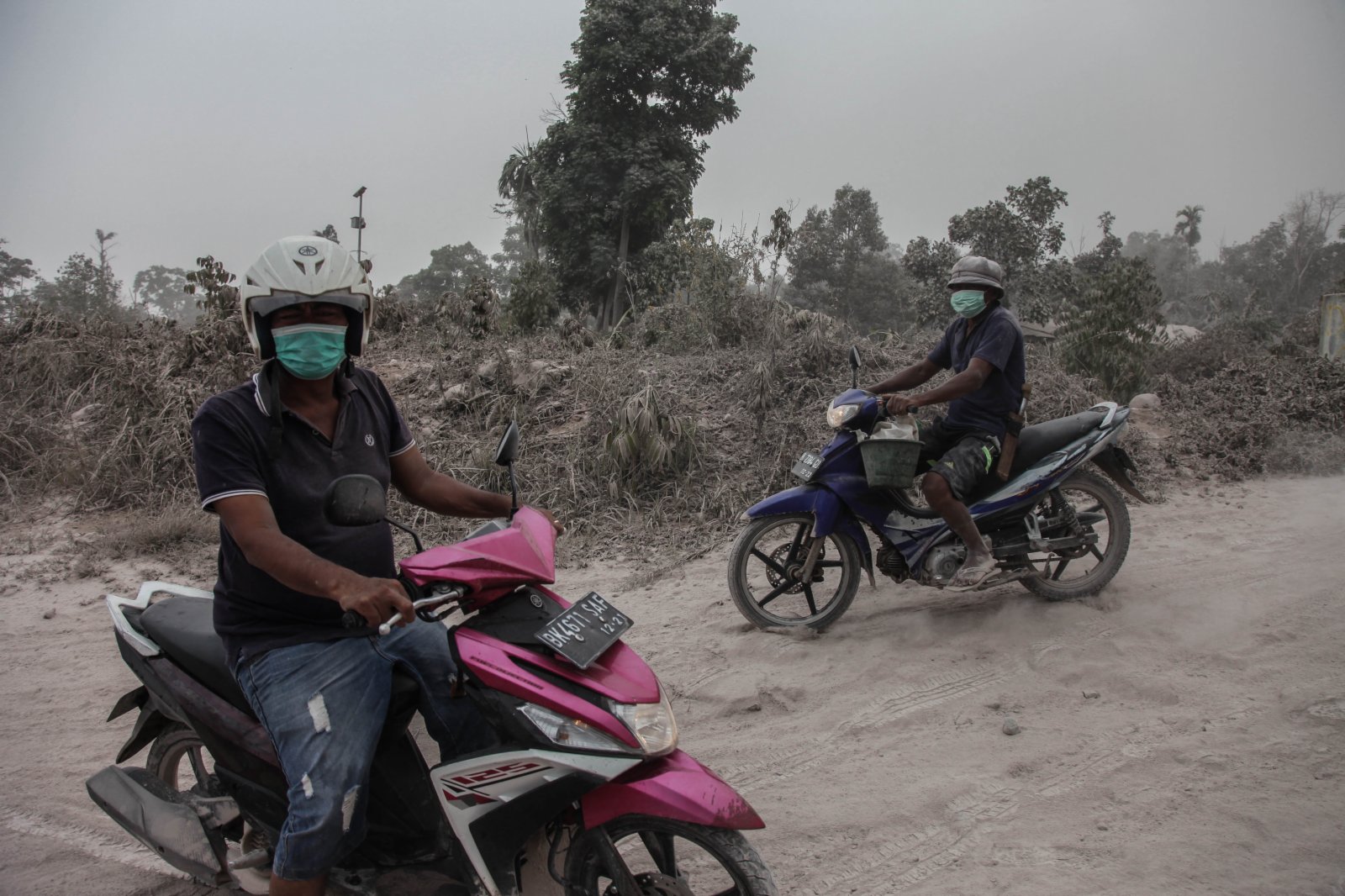 3月2日，印度尼西亞北蘇門答臘省卡羅的居民行駛在火山灰覆蓋的道路上。