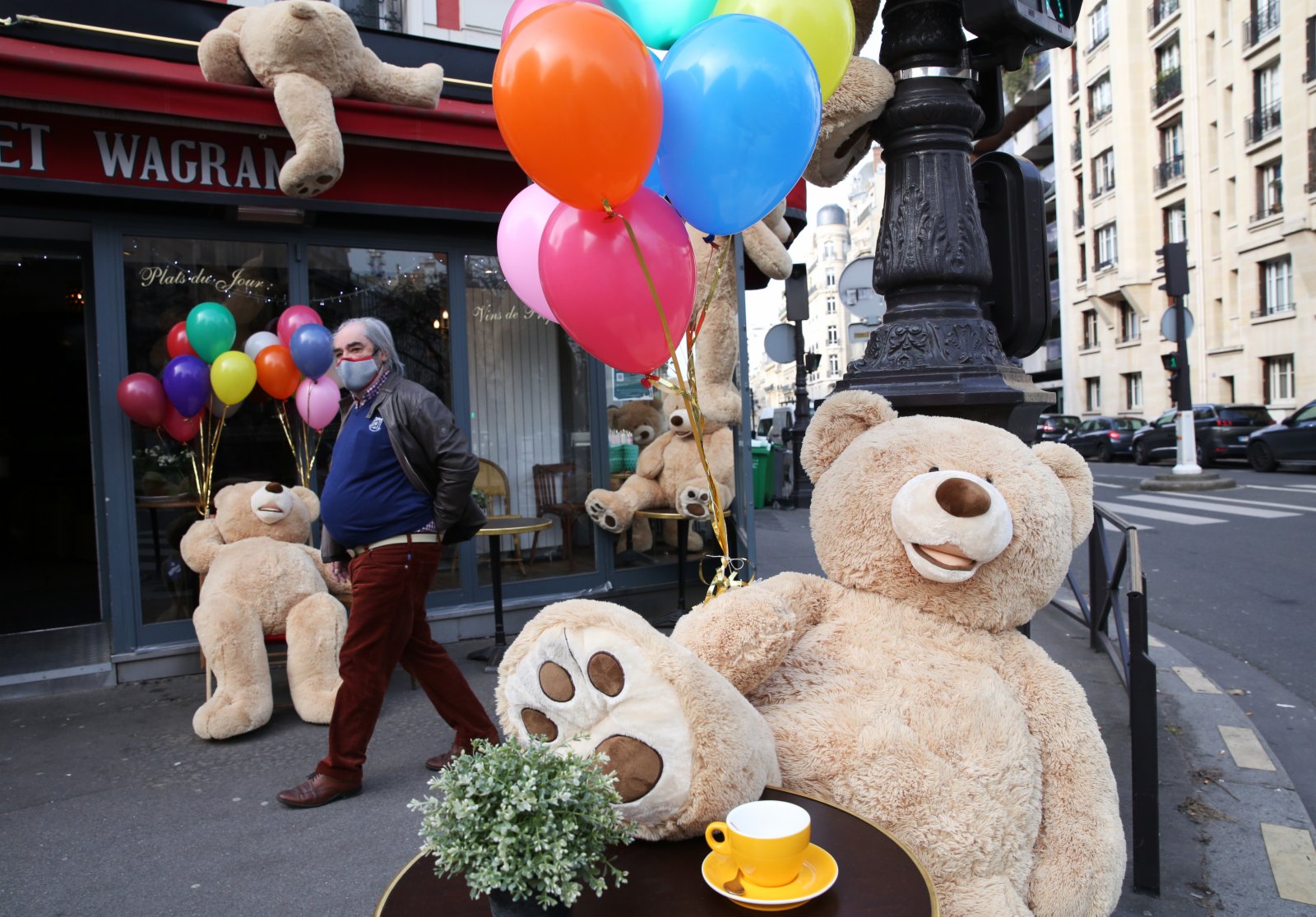 3月3日，一名男子走過法國巴黎街頭一家餐館外的玩具熊。（新華社）