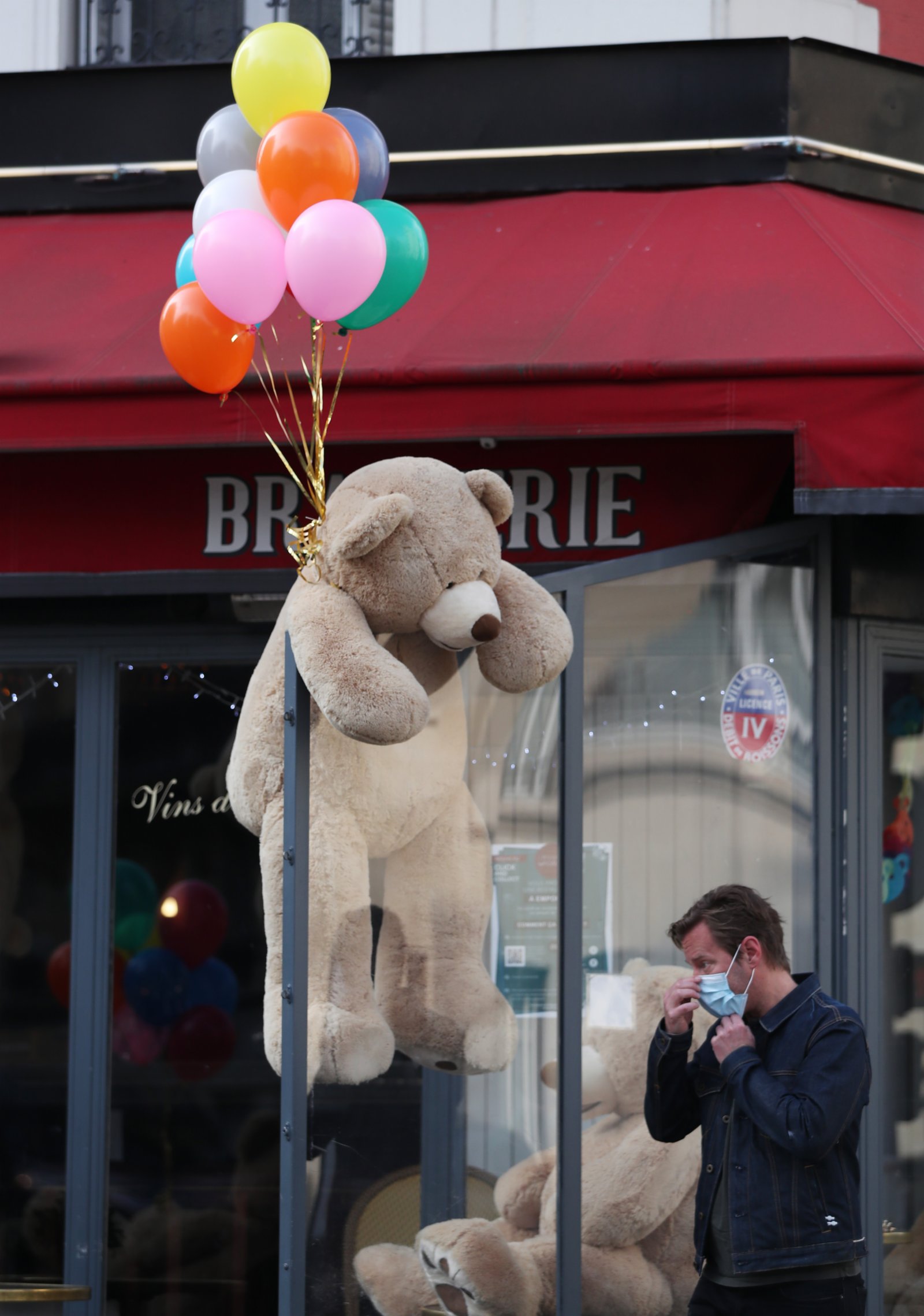 3月3日，一名男子走過法國巴黎街頭一家餐館外的玩具熊。（新華社）