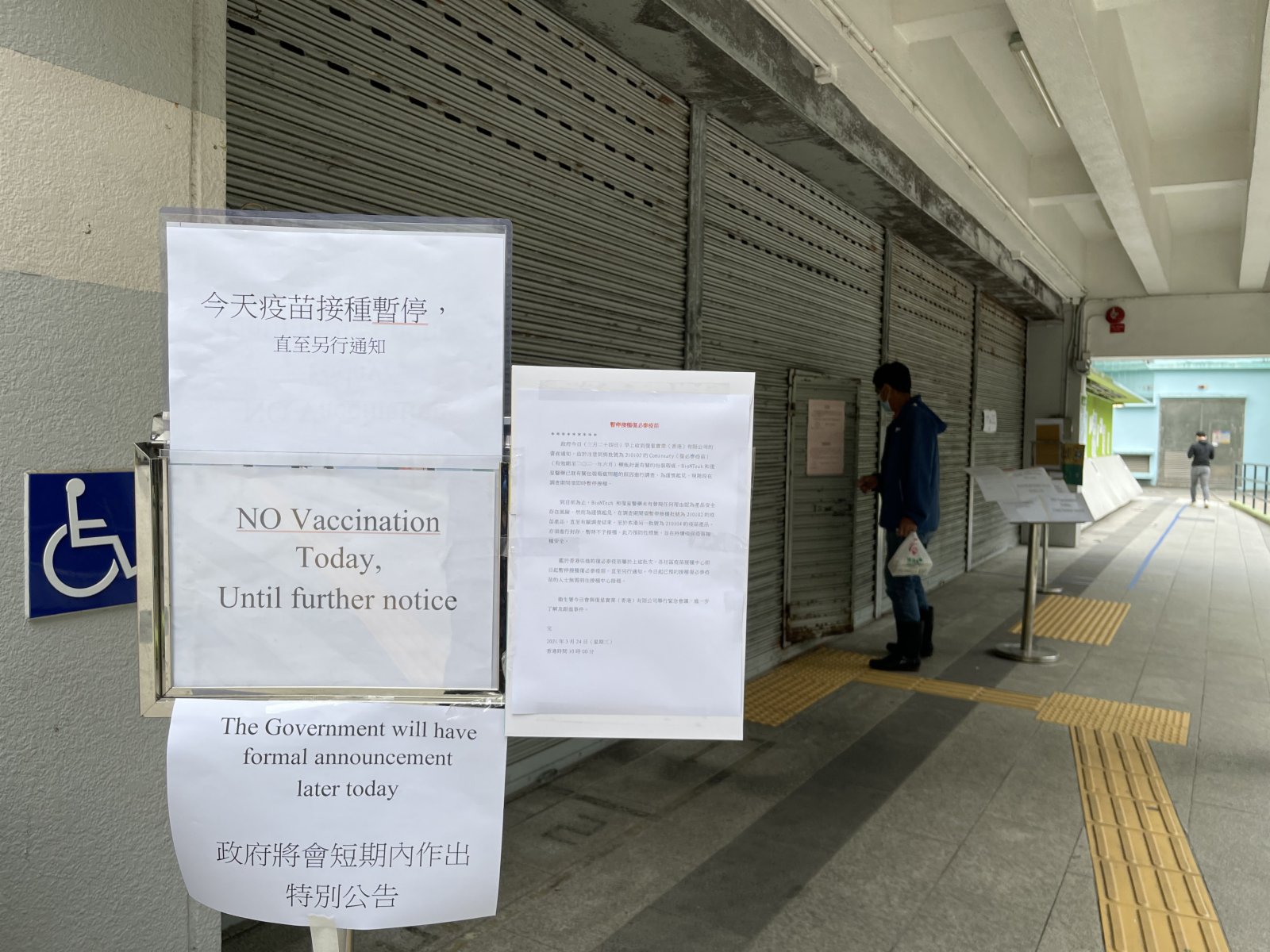 提供接種「復必泰」疫苗的觀塘曉光街體育館，張貼公告「今日疫苗接種暫停，直至另行通知」，接種中心大門關閉，只有少量工作人員進出場館。有部分路過的市民會駐足查看政府關於暫停「復必泰」疫苗新聞公報，並將信息告知家人，也有市民表示，希望政府盡快公布詳情，證明疫苗的安全性，否則會慎重考慮是否接種疫苗。（大公文匯全媒體記者攝）
