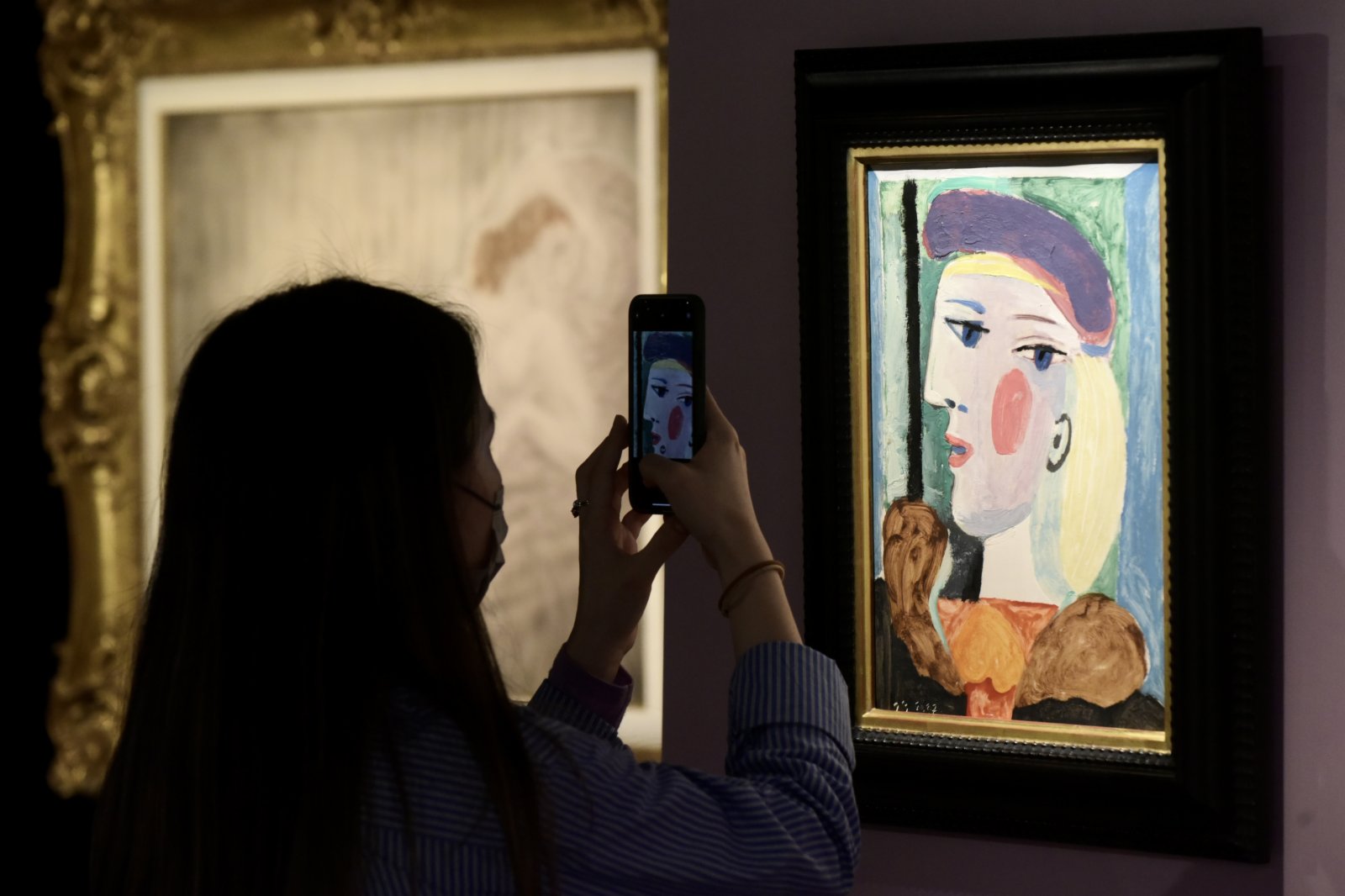 圖為入場人士觀賞巴布羅·畢加索的《戴淡紫色貝雷帽的女子》。
