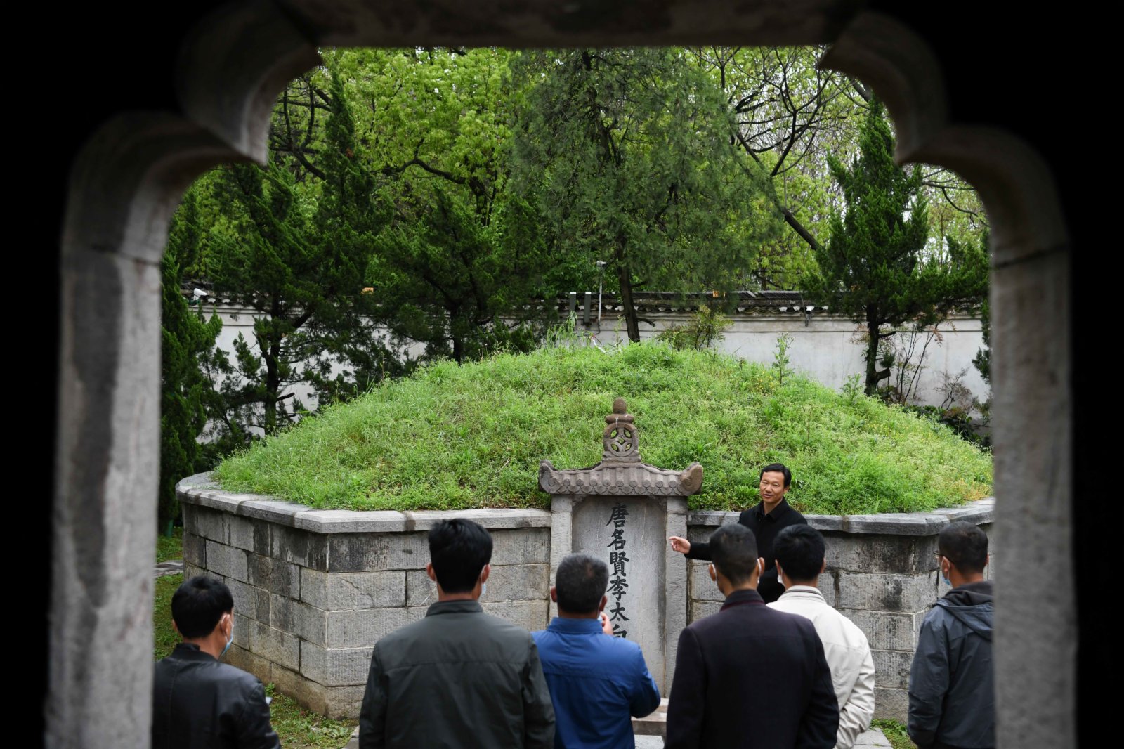 4月1日,谷常新(後)在李白墓園內向遊客介紹李白墓。(新華社) 4月1日,谷常新(後)在李白墓園內向遊客介紹李白墓。(新華社)