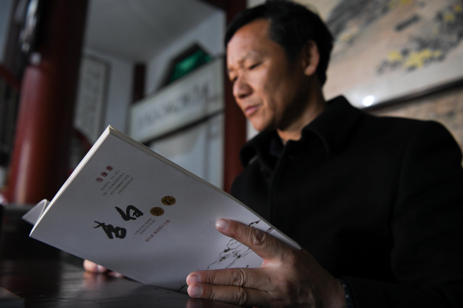 4月1日,谷常新在李白文化園內翻閱自己參與編撰的圖書《李白遊蹤》。(新華社) 4月1日,谷常新在李白文化園內翻閱自己參與編撰的圖書《李白遊蹤》。(新華社)