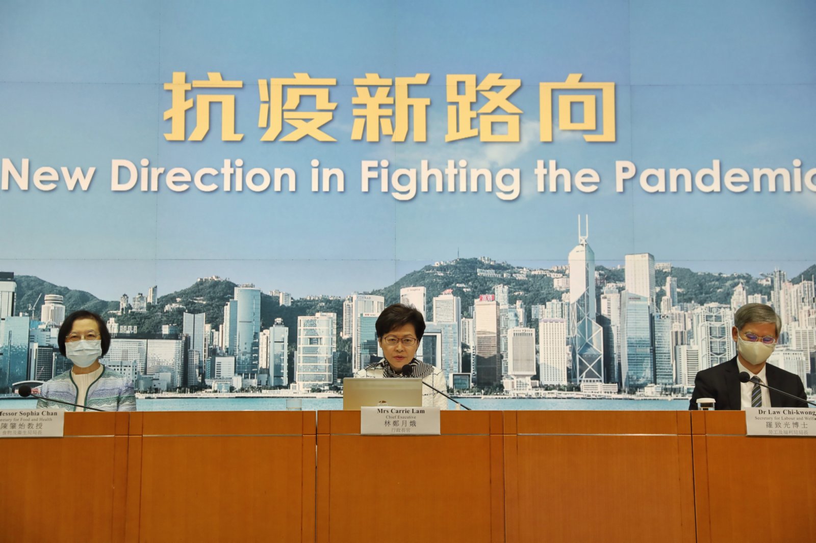 特首官林鄭月娥(中)在記者會上表示，第四波疫情明顯受控，達到階段性成果，從全球客觀標準來看，香港已屬於低風險地區。(香港中通社)