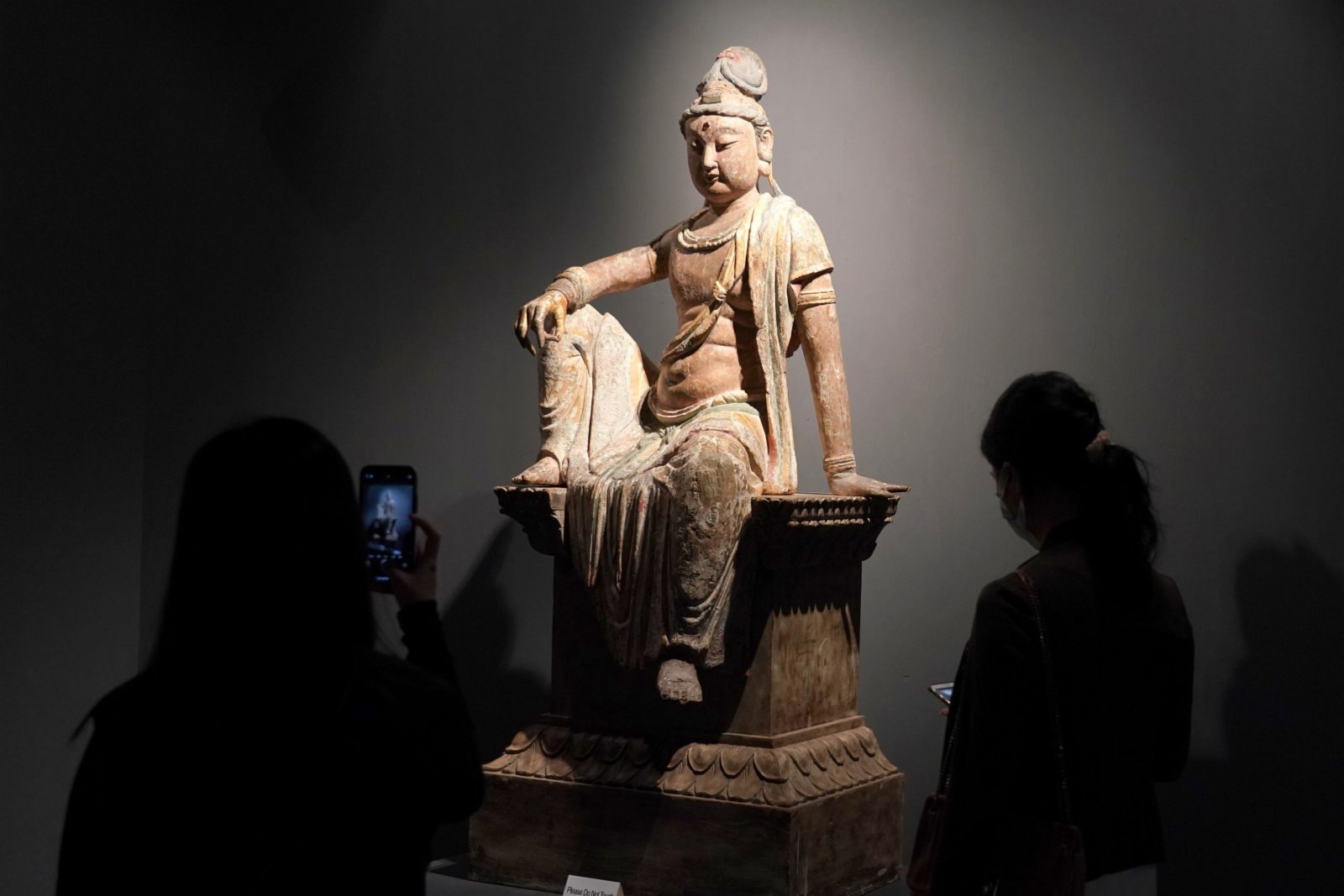 觀眾拍攝木雕加彩觀世音菩薩坐像。