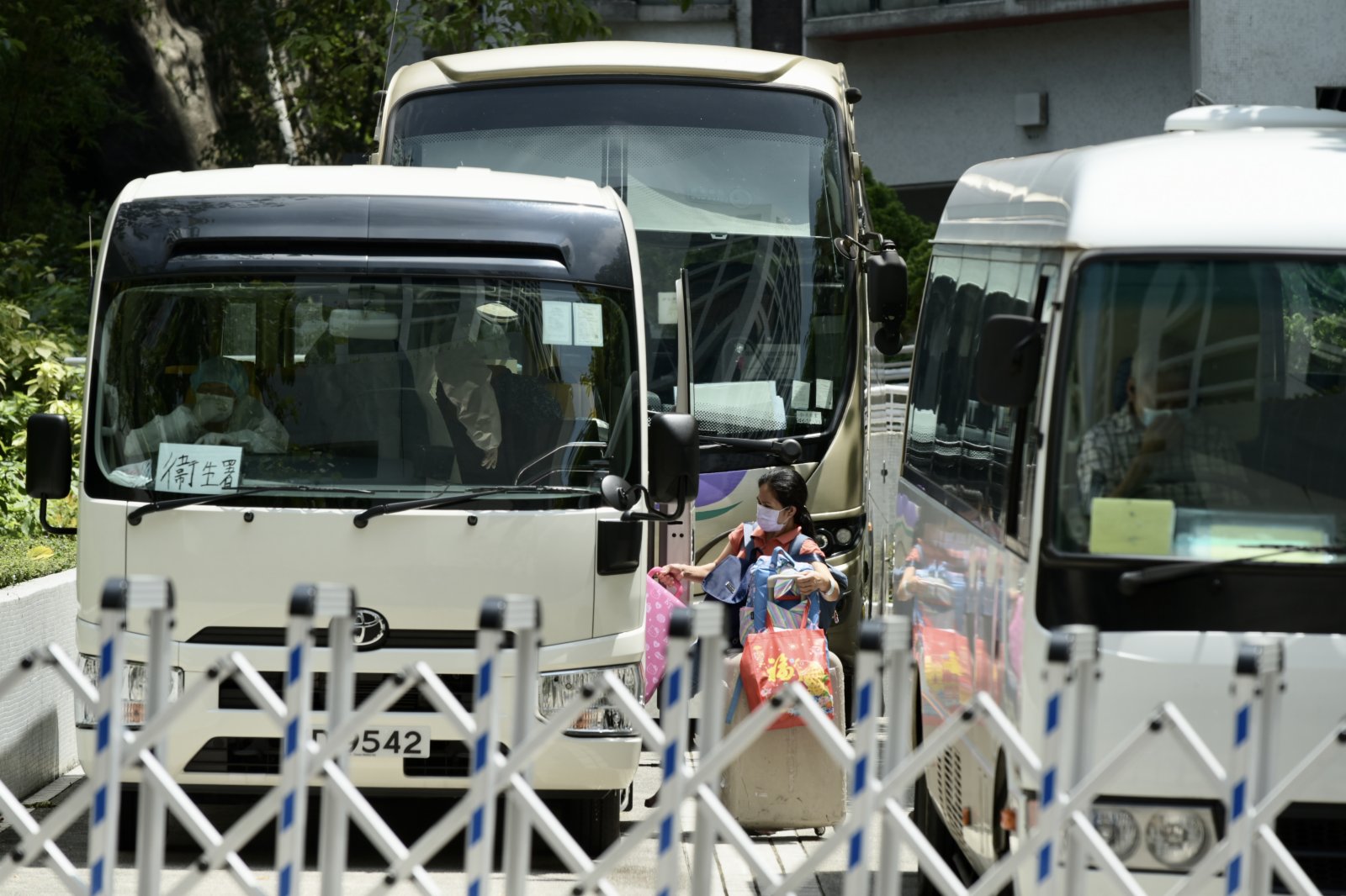 圖為住戶登上衞生署車輛前往檢疫中心。（中新社）