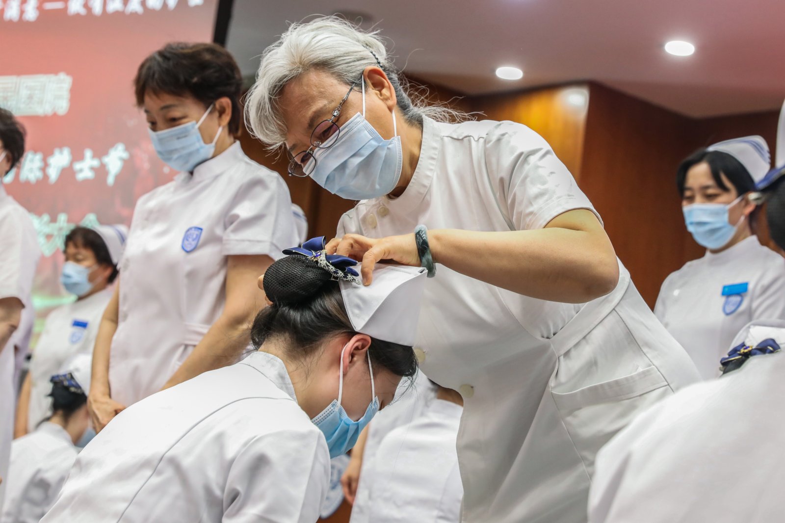 北京大學人民醫院的護理屆前輩閆鳳玲（中）為新入職護士授帽。