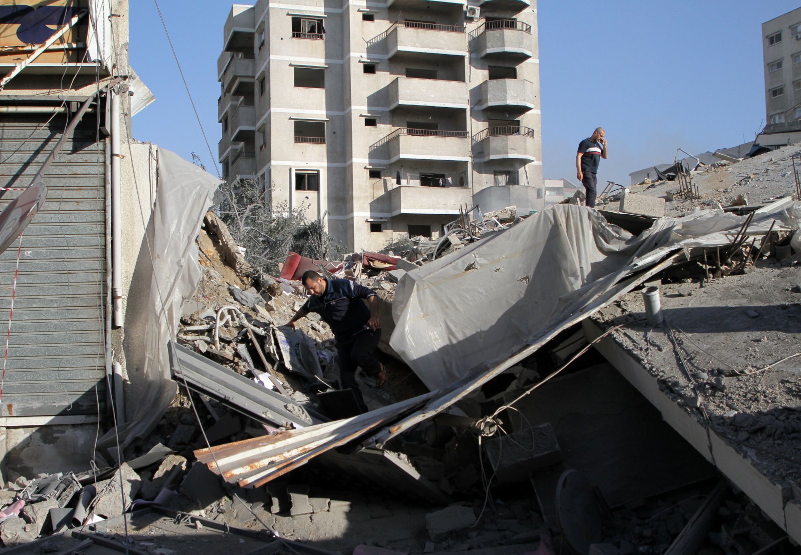 5月14日，巴勒斯坦人在加沙城查看被以軍空襲摧毀的一處哈馬斯銀行廢墟。
