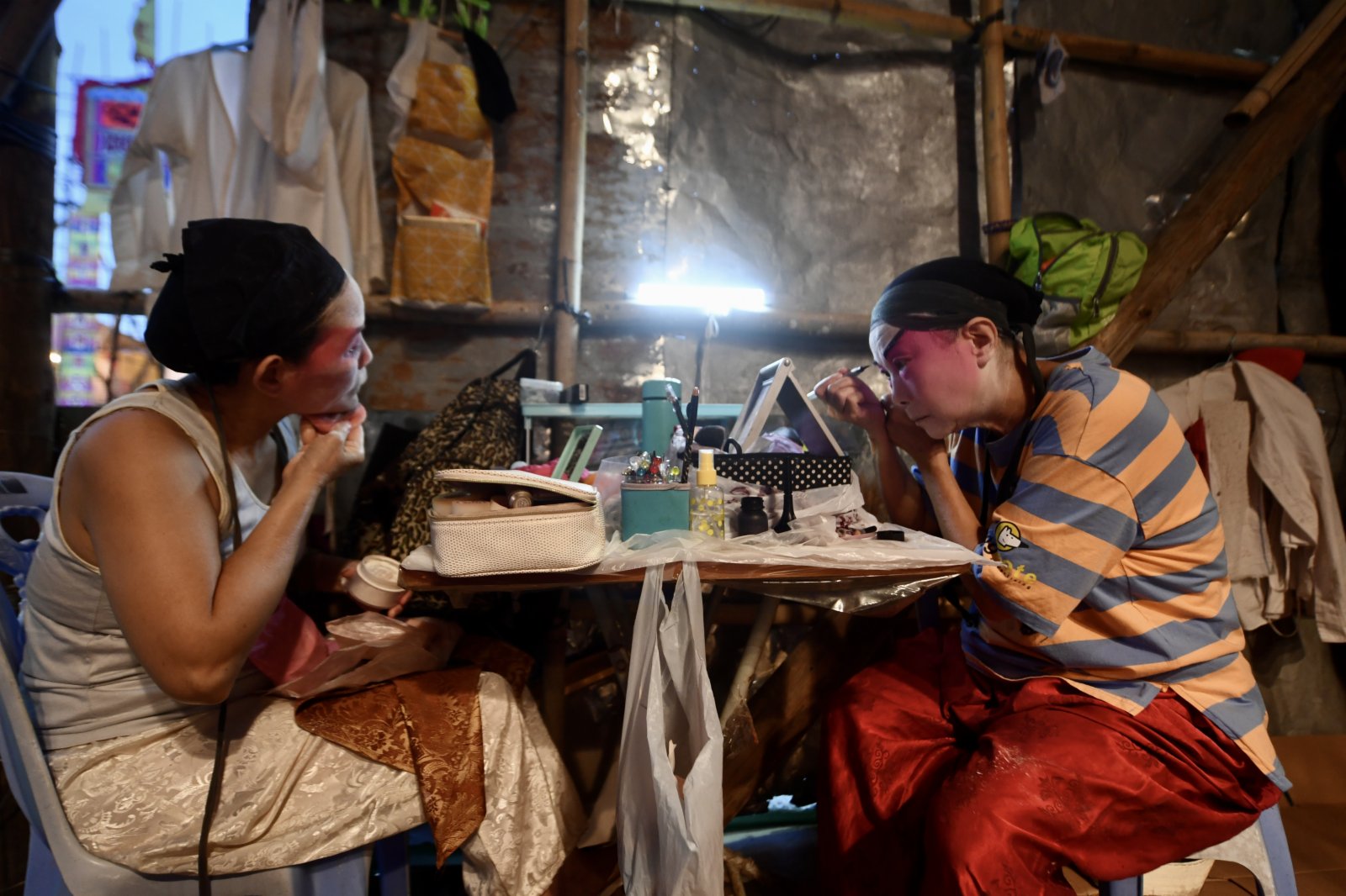 圖為表演者於戲棚內畫臉譜。（中新社）