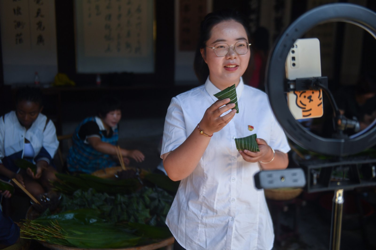 6月8日，湖源鄉的青年黨員志願者通過直播帶貨的形式為特色灰湯粽擴大知名度。（新華社）