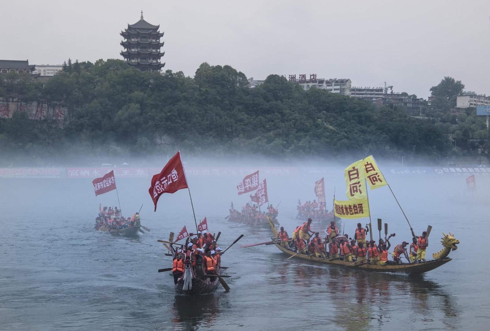 6月12日，參賽龍舟隊在漢江上奮勇競技。（新華社）