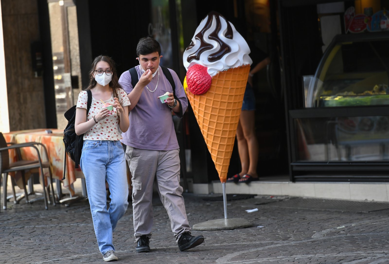 6月17日，在德國法蘭克福，人們手拿冰激淩從街頭走過。（新華社）