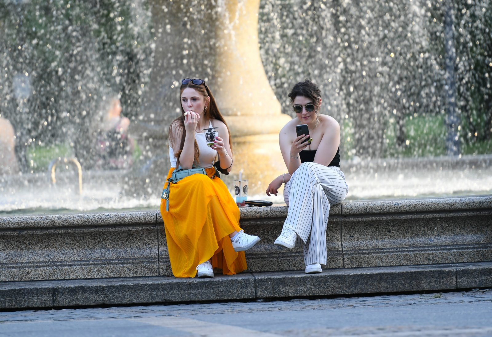 6月17日，在德國法蘭克福，人們在一處噴泉旁乘涼。（新華社）