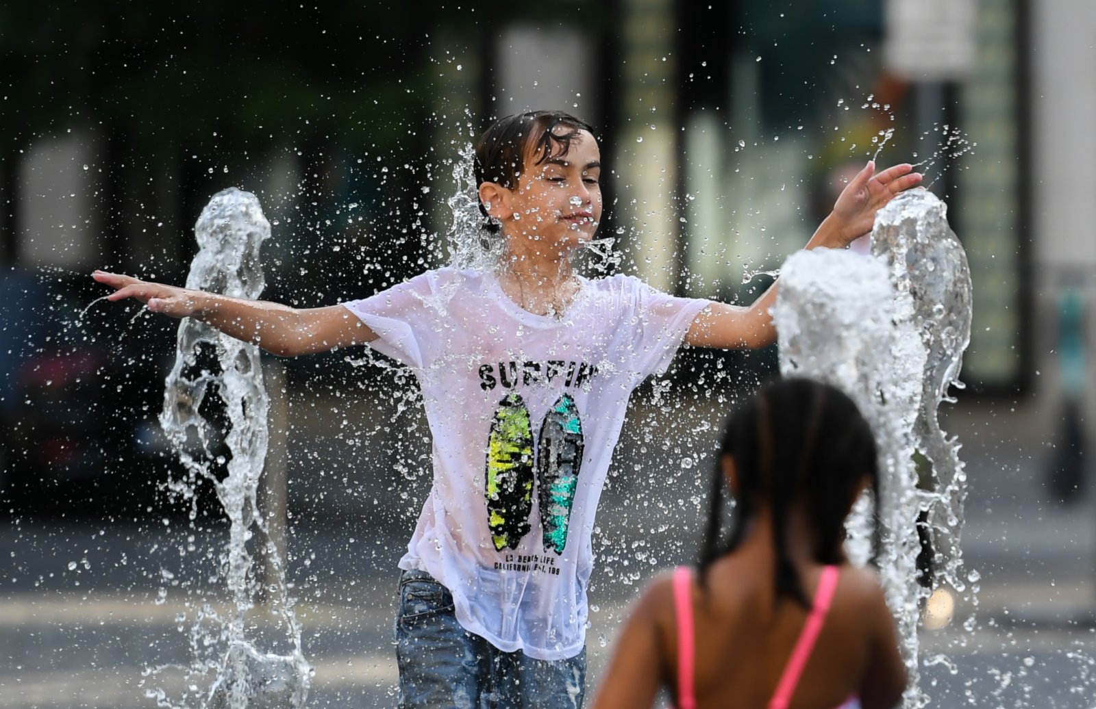 6月17日，在德國法蘭克福，兒童在街頭戲水納涼。（新華社）