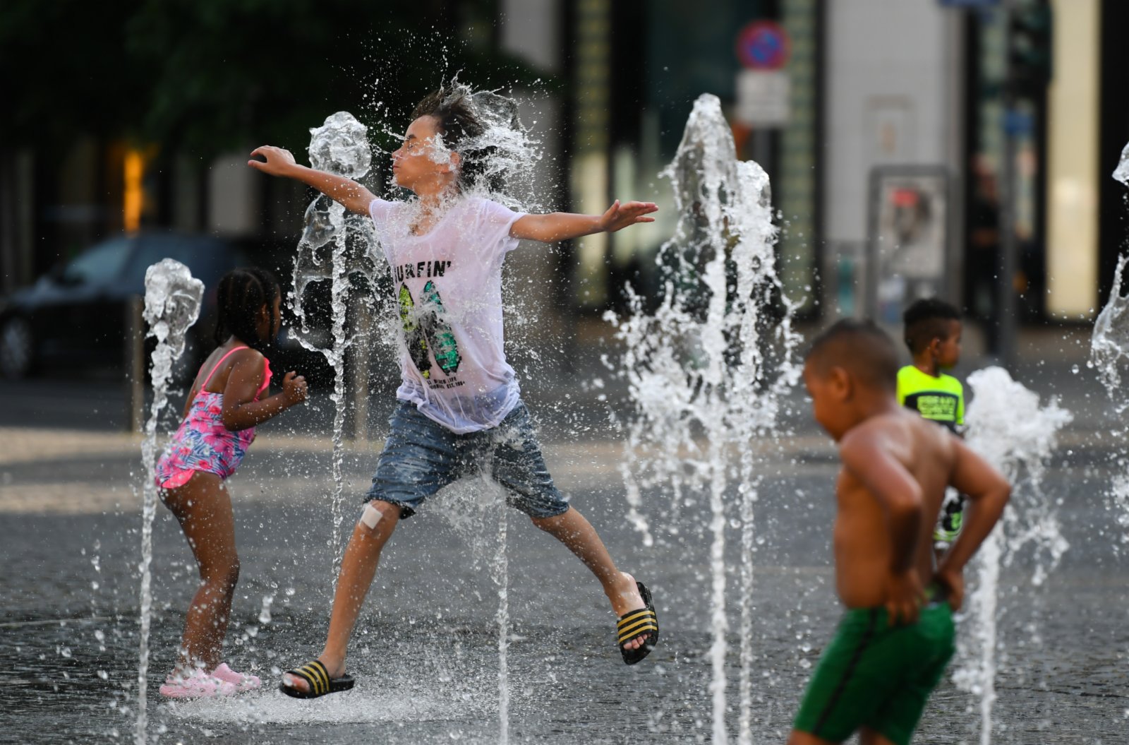 6月17日，小朋友在德國法蘭克福街頭戲水納涼。（新華社）